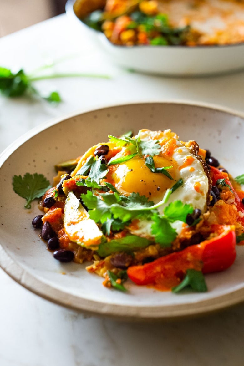 How to Make Chilaquiles! A classic Mexican dish made with stewed corn tortillas (or chips) that can be served as breakfast, lunch or dinner. The best part? This highly adaptable meal can be made in under 20 minutes, perfect for busy weeknights! #chilaquiles #vegetarian #mexican #rojo #verde