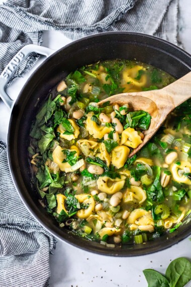 Tortellini Soup Recipe with Spinach, Basil, and white beans in a Dutch oven.