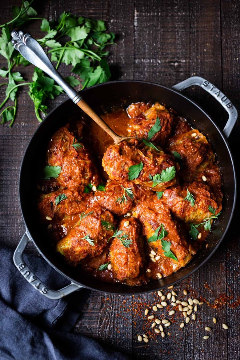 Turkish Cabbage Rolls - filled with ground lamb, bulgar, pine nuts and fragrant spices, bathed in the most delicious Turkish Tomato Sauce. This can be made ahead and reheated for your special gathering. #cabbagerolls #stuffedcabbage #turkishcabbagerolls #turkishrecipes #lambrecipes #cabbagerecipes 