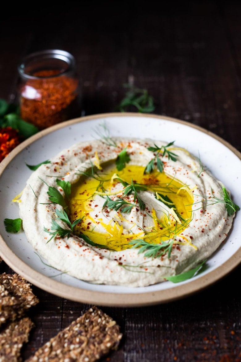 Lemony Artichoke White Bean Dip - a quick and easy Vegan Appetizer (a twist on "hummus") that can be made in 10 minutes flat. Great for parties and gatherings and made with simple pantry ingredients! #artichokedip #vegandip #veganappetizer #whitebeandip #whitebeanhummus