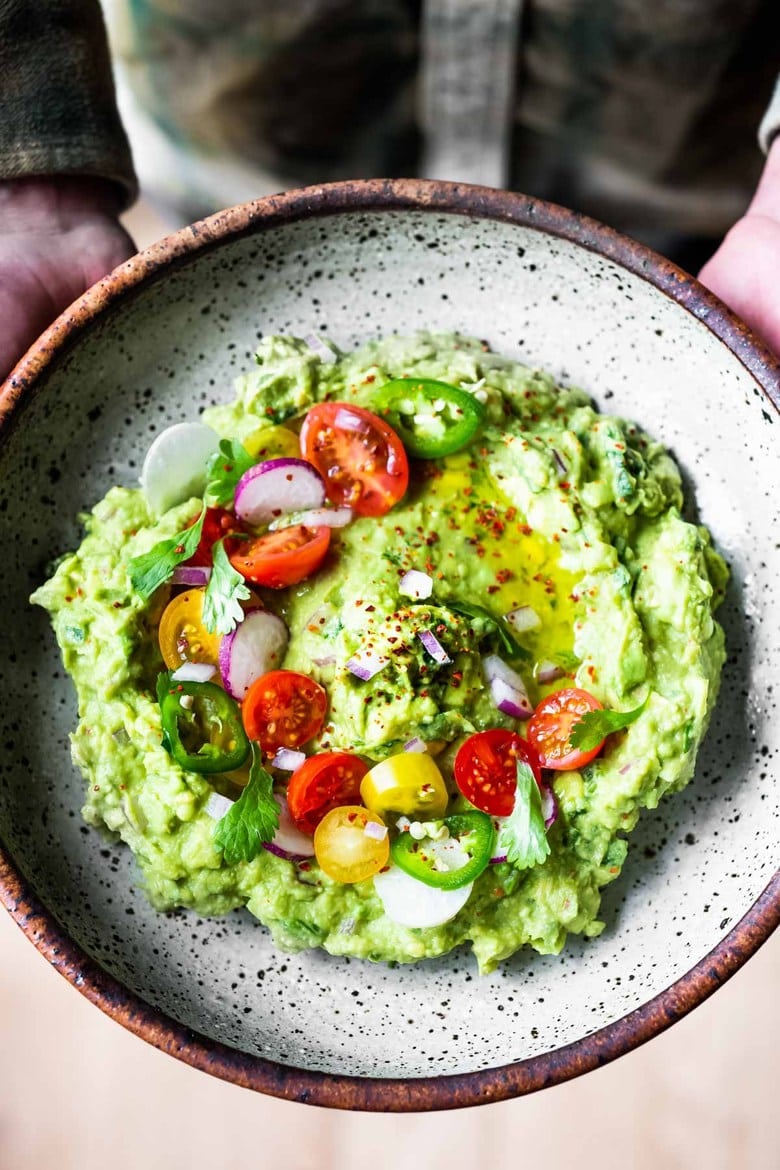 How to make the most delicious guacamole! A simple easy recipe for Guacamole that will be the hit of your party! A flavorful Mexican appetizer that is vegan, gluten-free and healthy. #guac #guacamole #guacamolerecipe #avocadodip 