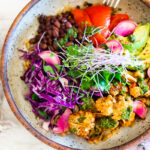 Smokey Cauliflower Chimichurri Bowls!  These filling vegan bowls are full of flavor and loaded up with healthy veggies. Served over seasoned black beans (and optional rice) with Mexican Slaw, radishes, avocado, cilantro and pickled onions. #roastedcauliflower #bowls #veganbowls #veganrecipes #buddhabowls #chimichurri #eatclean #cleaneating #plantbased #healthybowls