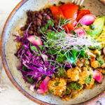 Smokey Cauliflower Chimichurri Bowls! These filling vegan bowls are full of flavor and loaded up with healthy veggies. Served over seasoned black beans (and optional rice) with Mexican Slaw, radishes, avocado, cilantro and pickled onions. #roastedcauliflower #bowls #veganbowls #veganrecipes #buddhabowls #chimichurri #eatclean #cleaneating #plantbased #healthybowls