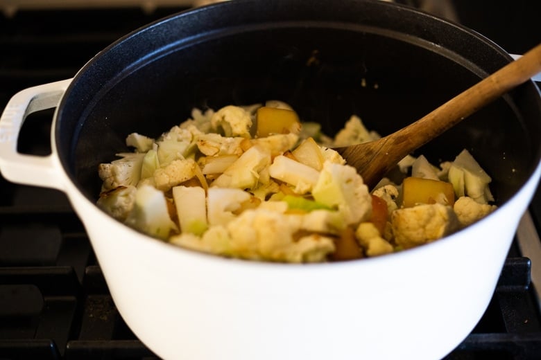 soup pot with chopped cauliflower, onions, and apples.
