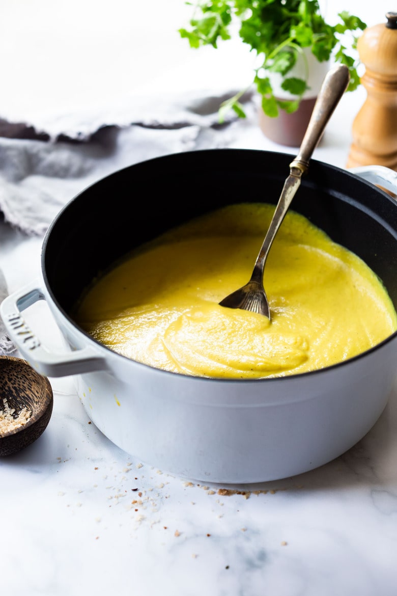 soup pot with creamy vegan curried cauliflower soup and ladle.