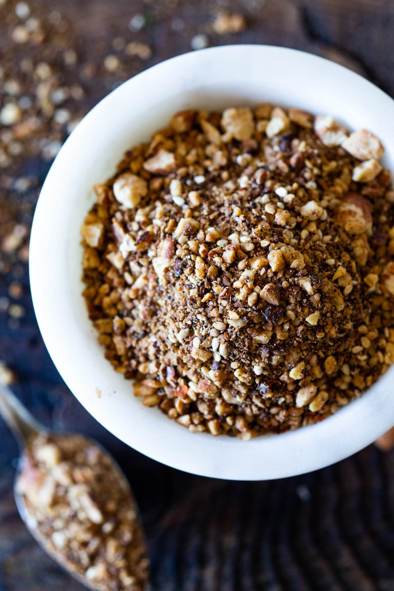 Dukkah is a flavorful Egyptian spice blend made with toasted nuts, seeds and fragrant spices. Use dukkah on soups, salads, poached eggs, avocado toast, hummus, fish, chicken and roasted veggies... to give an earthy flavor and delicious crunch! #dukkah #zaatar #middleeasternspice #howtomkaedukkah #dukkahrecipe 