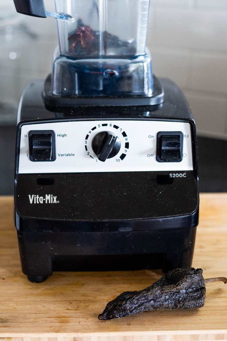 grinding dried chilies to make homemade chili powder for taco seasoning