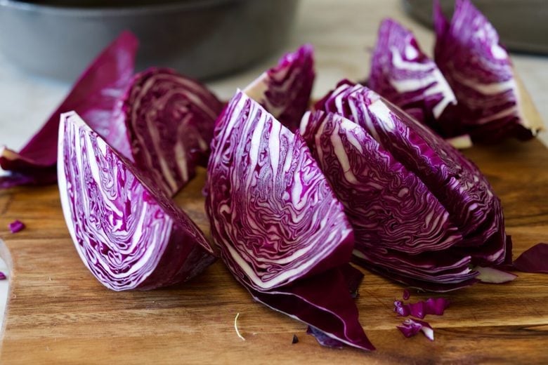 wedges of purple cabbage on wood board. 