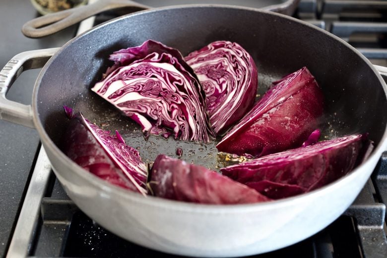 wedges of purple cabbage in large oven-proof pan.