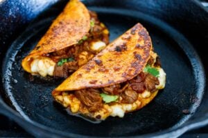 A simple authentic recipe for Birria Tacos, a flavorful Mexican beef or lamb stew that is spooned into tortillas with melty cheese, pickled onions, avocado and cilantro. Cook this in a ducth oven, slow cooker, or instant pot. 