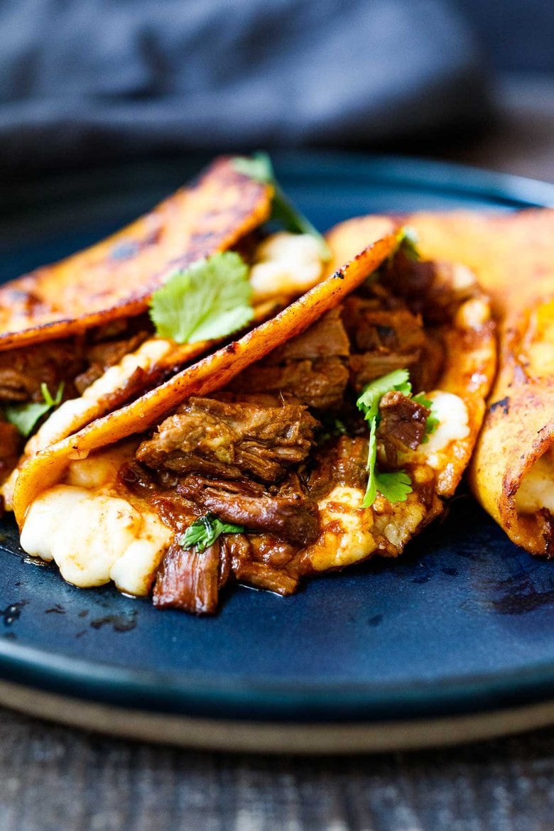 A simple authentic recipe for Birria Tacos, a flavorful Mexican beef or lamb stew that is spooned into tortillas with melty cheese, pickled onions, avocado and cilantro. Cook this in a ducth oven, slow cooker, or instant pot.