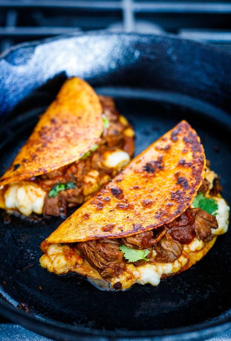 A simple authentic recipe for Birria Tacos, a flavorful Mexican beef or lamb stew that is spooned into tortillas with melty cheese, pickled onions, avocado and cilantro. Cook this in a ducth oven, slow cooker, or instant pot. 