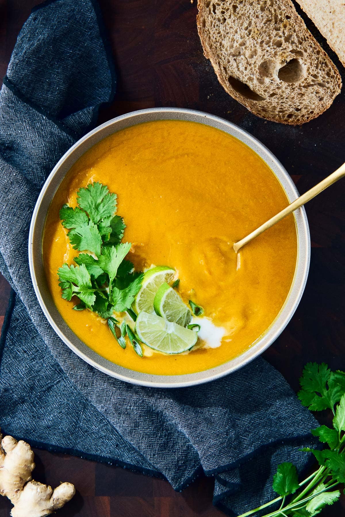 bowl of sweet potato soup with coconut milk, cilantro, green onions, and lime. 