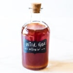 A simple Rose Tincture that opens the heart, quiets the mind and soothes the soul. Calming and uplifting it aids in our overall wellbeing, balancing all 3 doshas. Made with simple ingredients, this takes only 15 minutes of hands-on time! Add a splash of this Wild Rose Elixer to sparkling water, champagne, tea, or cocktails. #tincture #rose #elixir #lovepotion