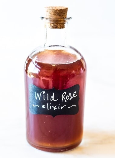 A simple Rose Tincture that opens the heart, quiets the mind and soothes the soul. Calming and uplifting it aids in our overall wellbeing, balancing all 3 doshas. Made with simple ingredients, this takes only 15 minutes of hands-on time! Add a splash of this Wild Rose Elixer to sparkling water, champagne, tea, or cocktails. #tincture #rose #elixir #lovepotion