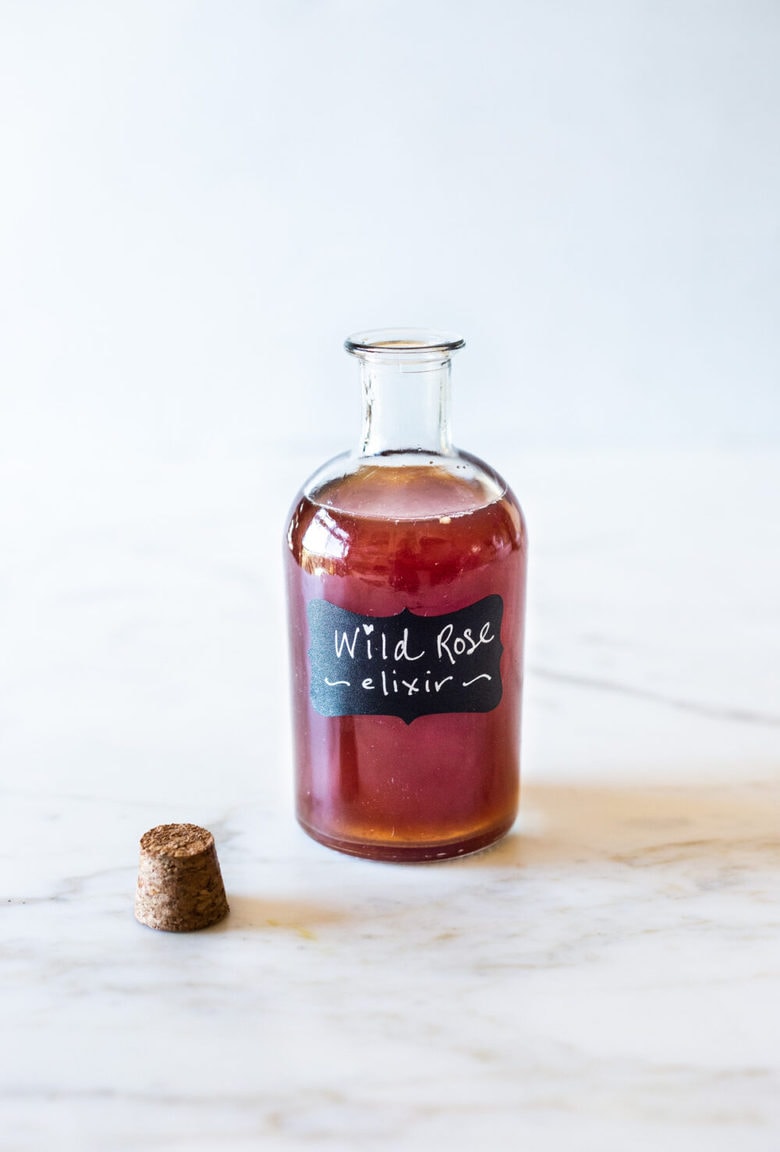 A simple Rose Tincture that opens the heart, quiets the mind and soothes the soul. Calming and uplifting it aids in our overall wellbeing, balancing all 3 doshas. Made with simple ingredients, this takes only 15 minutes of hands-on time! Add a splash of this Wild Rose Elixer to sparkling water, champagne, tea, or cocktails. #tincture #rose #elixir #lovepotion