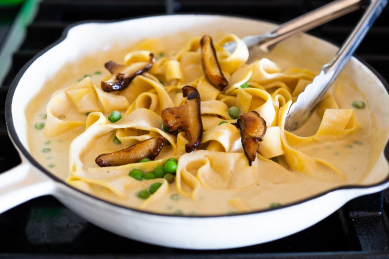 Vegan Alfredo for two, tossed in a delicious cashew (or hemp) cream, with sauteed mushrooms, Meyer lemon zest and a secret ingredient that gives this extra complexity and depth. Can be made in under 30 minutes! #veganalfredo #veganalfredosauce