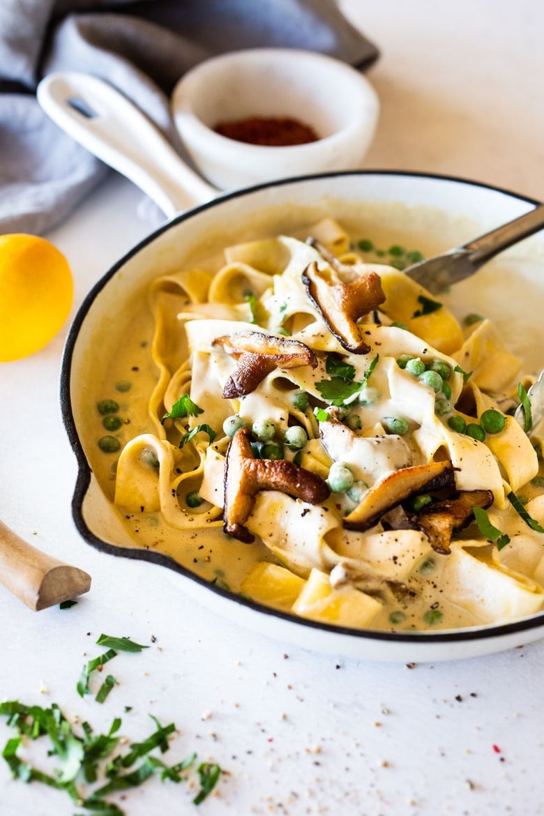 Vegan Alfredo for two, tossed in a delicious cashew (or hemp) cream, with sauteed mushrooms, Meyer lemon zest and a secret ingredient that gives this extra complexity and depth. Can be made in under 30 minutes! #veganalfredo #veganalfredosauce