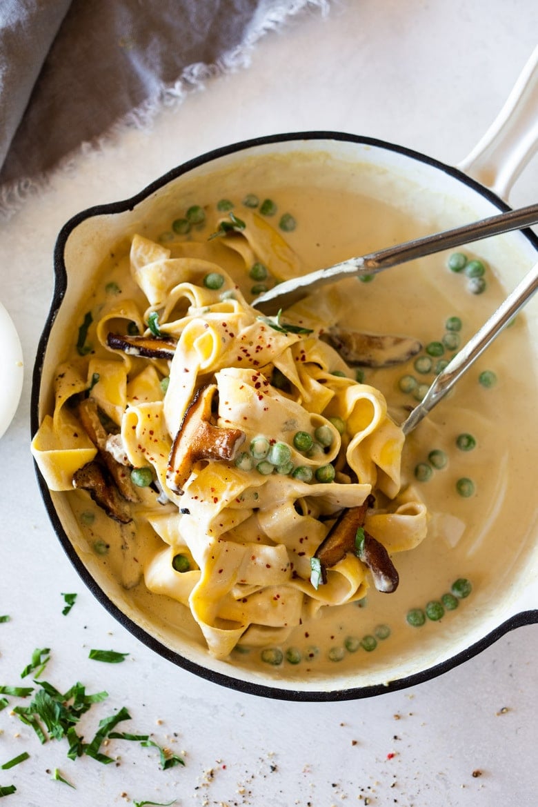 Vegan Alfredo for two, tossed in a delicious cashew (or hemp) cream, with sauteed mushrooms, Meyer lemon zest and a secret ingredient that gives this extra complexity and depth. Can be made in under 30 minutes! #veganalfredo #veganalfredosauce