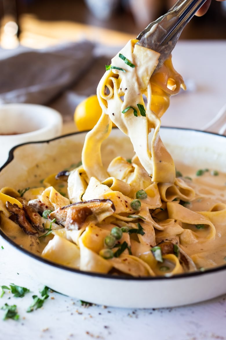 Vegan Alfredo for two, tossed in a delicious cashew (or hemp) cream, with sauteed mushrooms, Meyer lemon zest and a secret ingredient that gives this extra complexity and depth. Can be made in under 30 minutes! #veganalfredo #veganalfredosauce