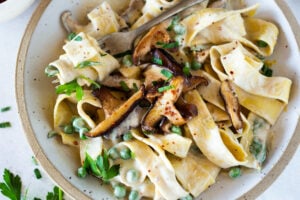 Vegan Alfredo for two, tossed in a delicious cashew (or hemp) cream, with sauteed mushrooms, Meyer lemon zest and a secret ingredient that gives this extra complexity, flavor and depth. Can be made in under 30 minutes! #veganalfredo #veganalfredosauce