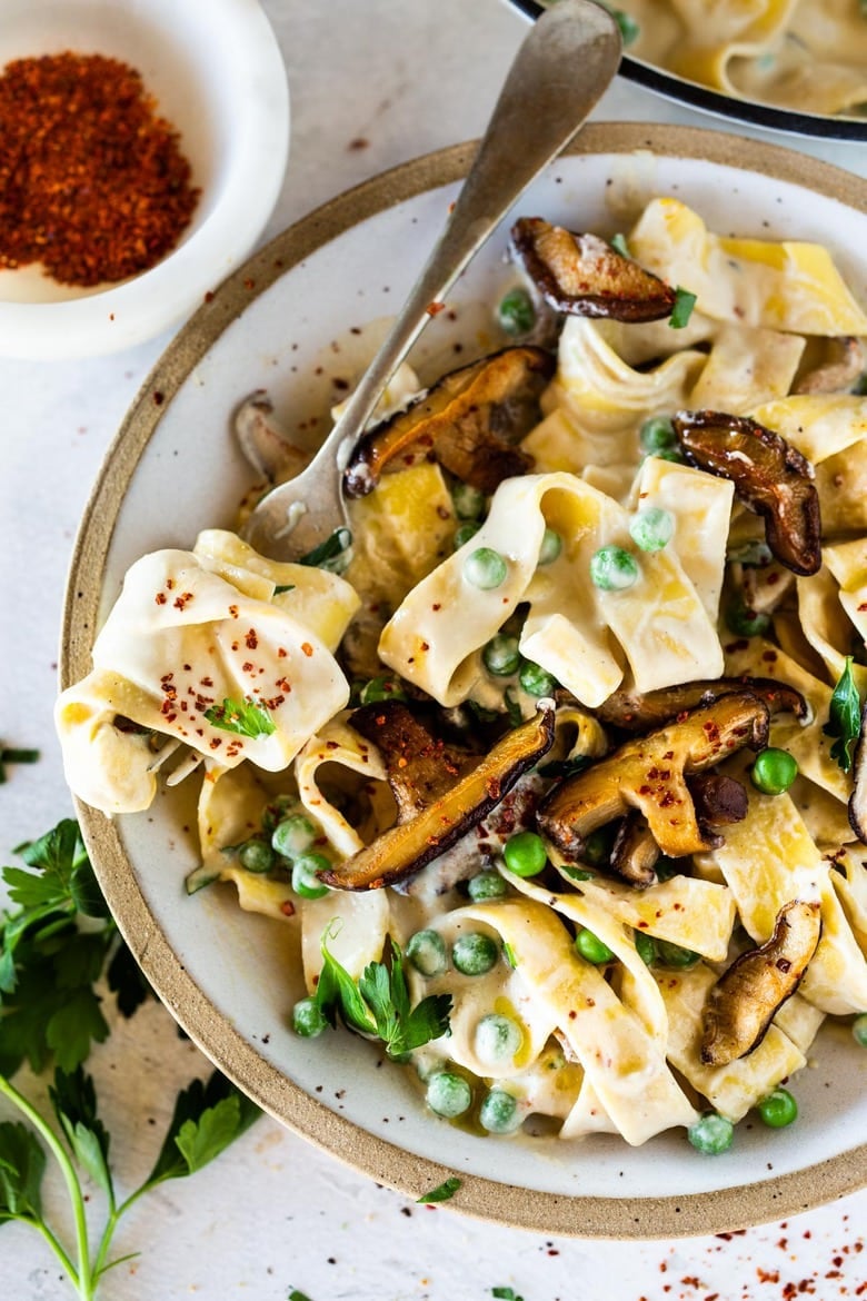Vegan Alfredo for two, tossed in a delicious cashew (or hemp) cream, with sauteed mushrooms, Meyer lemon zest and a secret ingredient that gives this extra complexity and depth. Can be made in under 30 minutes! #veganalfredo #veganalfredosauce