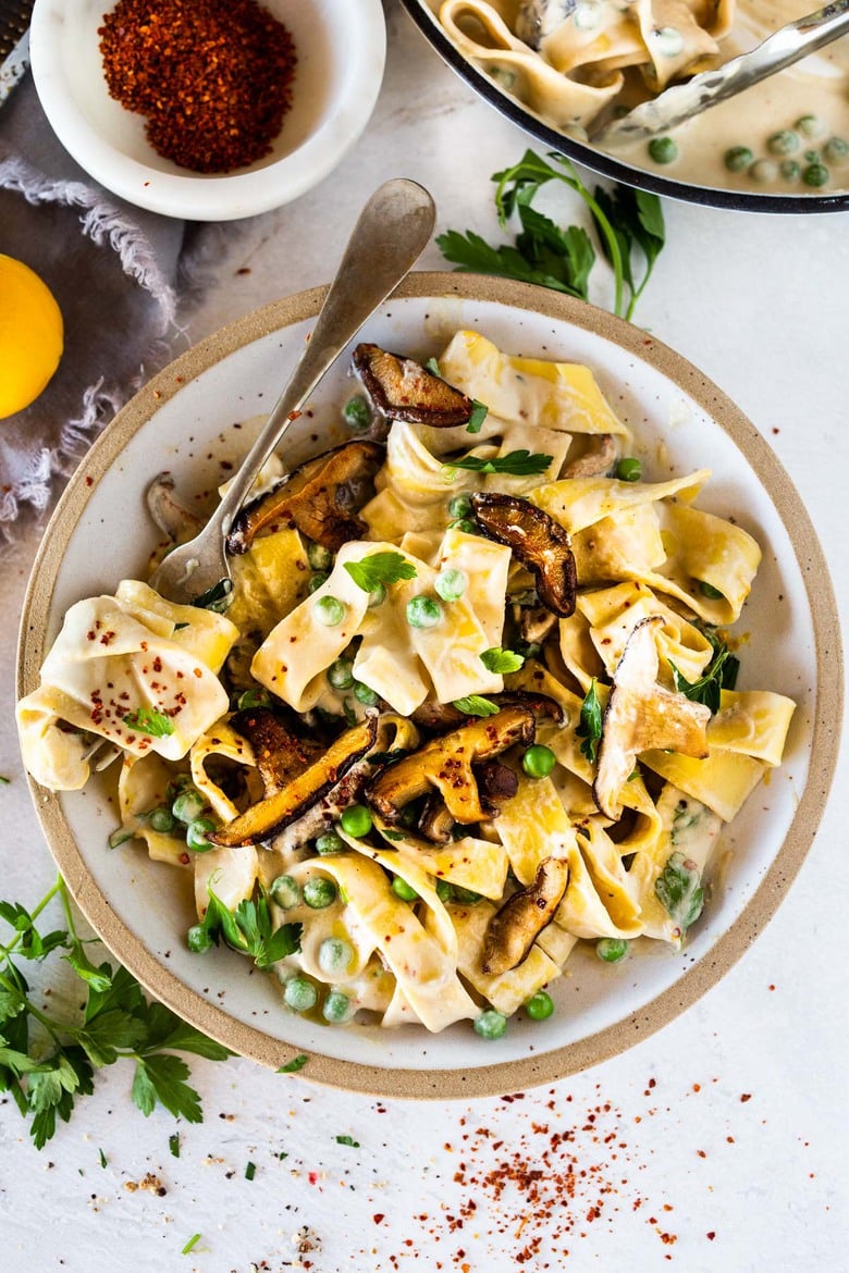 Vegan Alfredo for two, tossed in a delicious cashew (or hemp) cream, with sauteed mushrooms, Meyer lemon zest and a secret ingredient that gives this extra complexity and depth. Can be made in under 30 minutes! #veganalfredo #veganalfredosauce