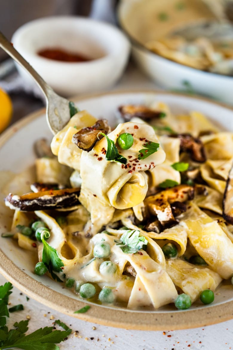 Vegan Alfredo for two, tossed in a delicious cashew (or hemp) cream, with sauteed mushrooms, Meyer lemon zest and a secret ingredient that gives this extra complexity and depth. Can be made in under 30 minutes! #veganalfredo #veganalfredosauce