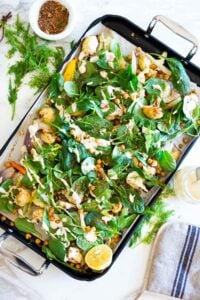Warm Winter Salad - a hearty, Middle Eastern salad made on a sheet pan with roasted cauliflower, carrots, fennel and chickpeas, topped with wilting spinach, drizzled with Everyday Tahini Sauce and sprinkled with fresh dill and Dukkah. Vegan and Gluten-free. #sheetpandinner #warmsalad #vegansalad #sheetpanmeal #wintersalad #spinachsalad #cauliflowersalad #wintersalad #warmsalad