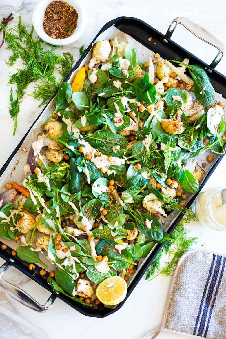 20 Plant-based Chickpea Recipes! ||Warm Winter Salad - a hearty, Middle Eastern salad made on a sheet pan with roasted cauliflower, carrots, fennel and chickpeas, topped with wilting spinach, drizzled with Everyday Tahini Sauce and sprinkled with fresh dill and Dukkah. Vegan and Gluten-free. #sheetpandinner #warmsalad #vegansalad #sheetpanmeal #wintersalad #spinachsalad #cauliflowersalad #wintersalad #warmsalad
