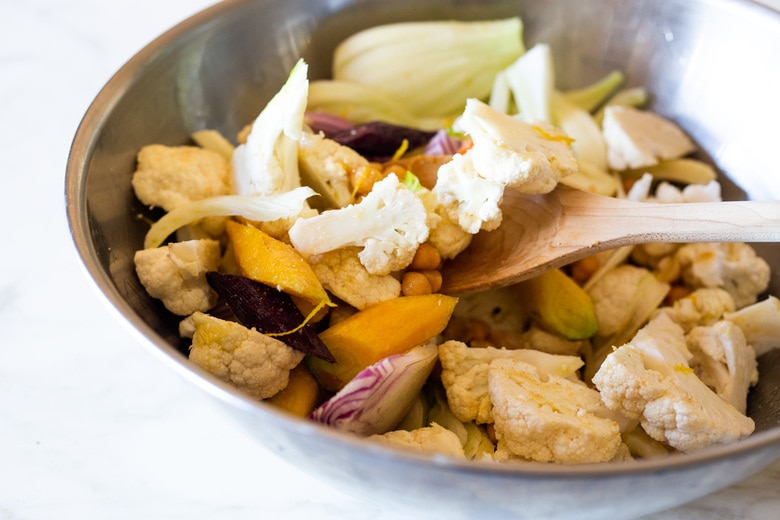 Warm Winter Salad - a hearty, Middle Eastern salad made on a sheet pan with roasted cauliflower, carrots, fennel and chickpeas, topped with wilting spinach, drizzled with Everyday Tahini Sauce and sprinkled with fresh dill and Dukkah. Vegan and Gluten-free. #sheetpandinner #warmsalad #vegansalad #sheetpanmeal #wintersalad #spinachsalad #cauliflowersalad #wintersalad #warmsalad 