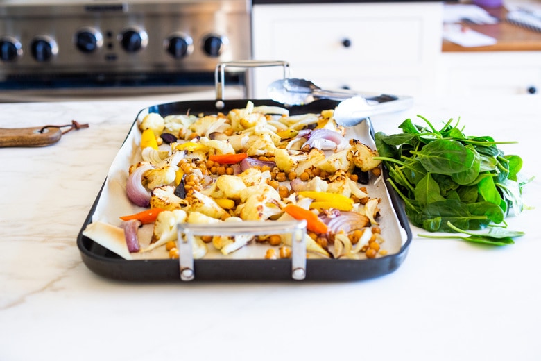 Warm Winter Salad - a hearty, Middle Eastern salad made on a sheet pan with roasted cauliflower, carrots, fennel and chickpeas, topped with wilting spinach, drizzled with Everyday Tahini Sauce and sprinkled with fresh dill and Dukkah. Vegan and Gluten-free. #sheetpandinner #warmsalad #vegansalad #sheetpanmeal #wintersalad #spinachsalad #cauliflowersalad #wintersalad #warmsalad 