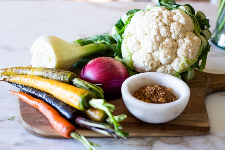 Warm Winter Salad - a hearty, Middle Eastern salad made on a sheet pan with roasted cauliflower, carrots, fennel and chickpeas, topped with wilting spinach, drizzled with Everyday Tahini Sauce and sprinkled with fresh dill and Dukkah. Vegan and Gluten-free. #sheetpandinner #warmsalad #vegansalad #sheetpanmeal #wintersalad #spinachsalad #cauliflowersalad #wintersalad #warmsalad 