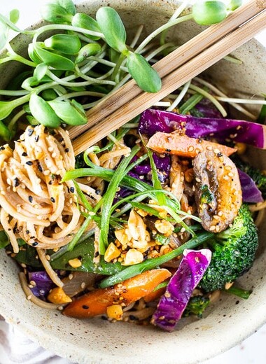 Flavorful Sesame Noodles, loaded up with healthy veggies and tossed in the most delicious, creamy, vegan Sesame Sauce! Make this in 20 minutes flat! Keep it vegan or add chicken- up to you! #sesamenoodles #vegan #noodlebowl