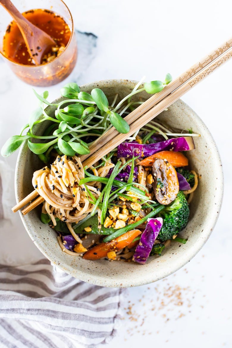 Creamy, vegan Sesame Noodles, loaded up with healthy veggies and tossed in the most delicious Sesame Sauce made with tahini paste! Make this in 20 minutes flat and keep it vegan or add chicken- up to you! #sesamenoodles #vegan #noodlebowl
