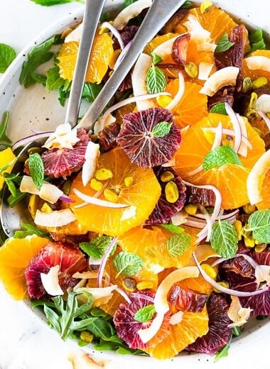 Citrus Salad with dates, arugula, mint, pistachios, and toasted coconut is dressed in the most flavorful Citrus Shallot Vinaigrette. It's deliciously juicy and vegan! #citrussalad #orangesalad