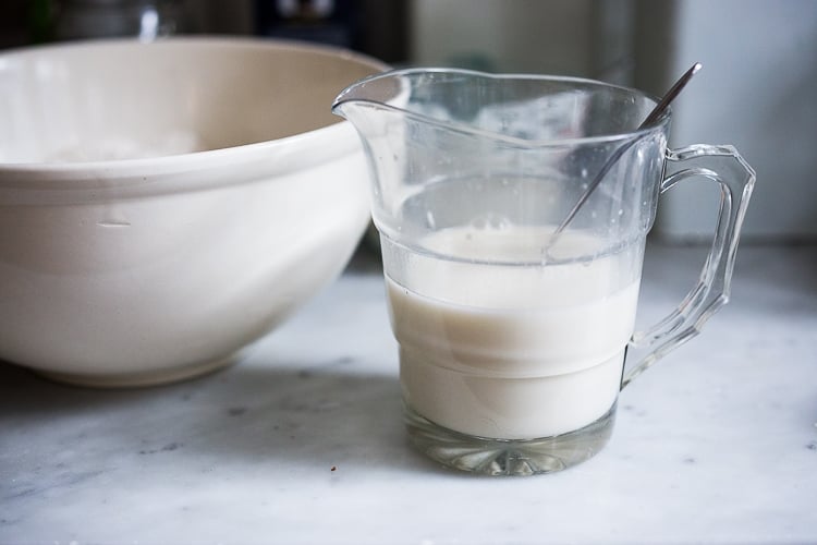 sourdough starter mixed with water in a glass measuring cup