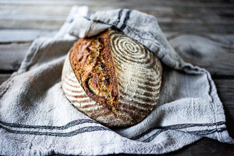 A simple EASY recipe for No-Knead Sourdough Bread that takes very little hands-on time, rising overnight and bakes in the morning.