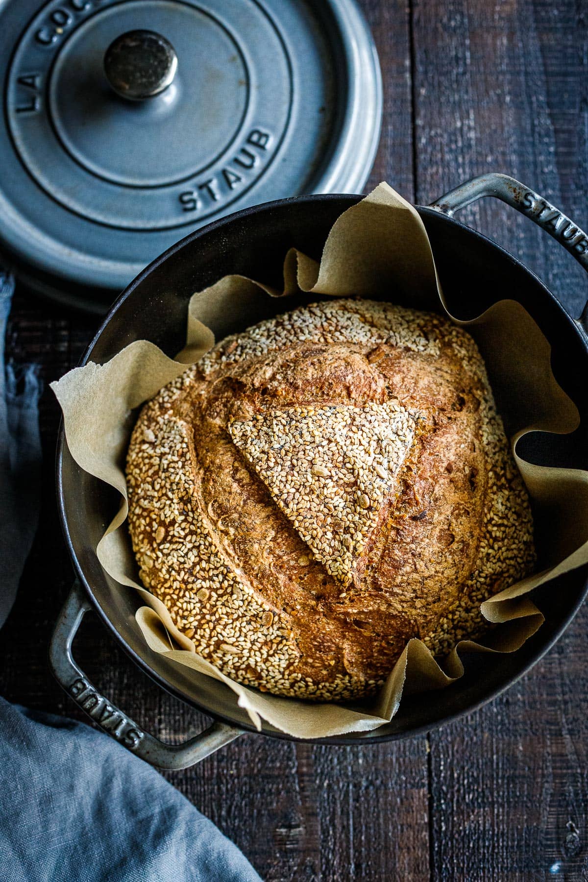 sourdough loaf in a dutch oven with parchment paper.