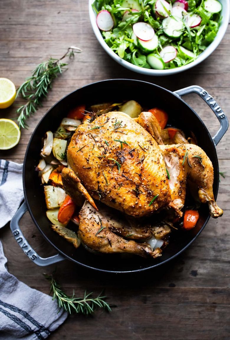 A simple easy recipe for roast chicken with lemon, garlic and rosemary, baked in the oven over vegetables. A delicious dinner recipe! #roastchicken