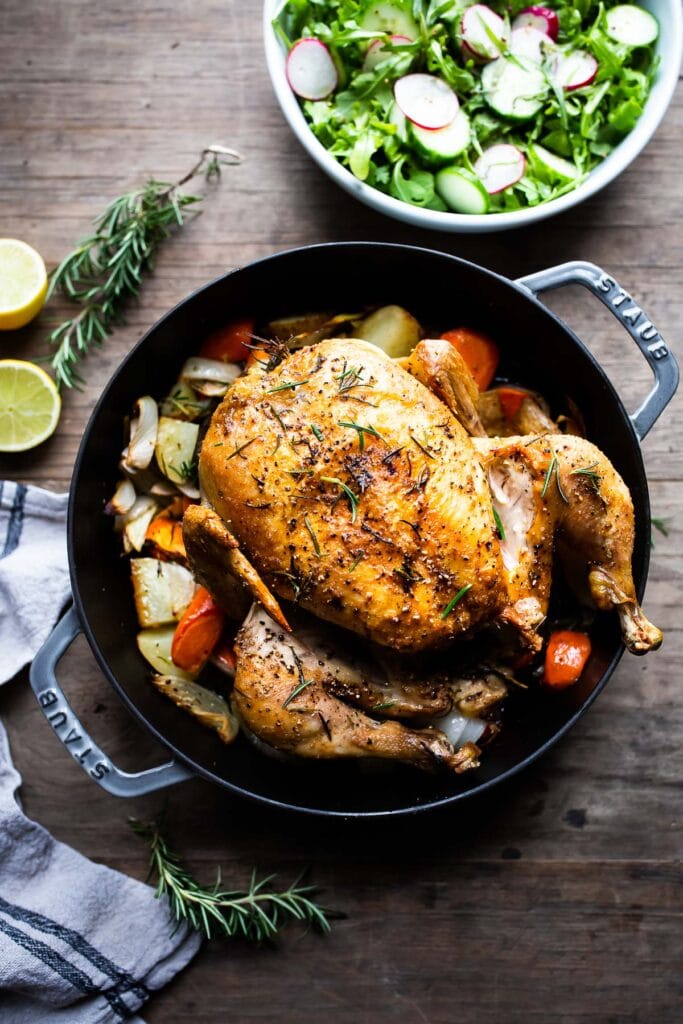 A simple easy recipe for roast chicken with lemon, garlic and rosemary, baked in the oven over vegetables. A delicious dinner recipe! #roastchicken