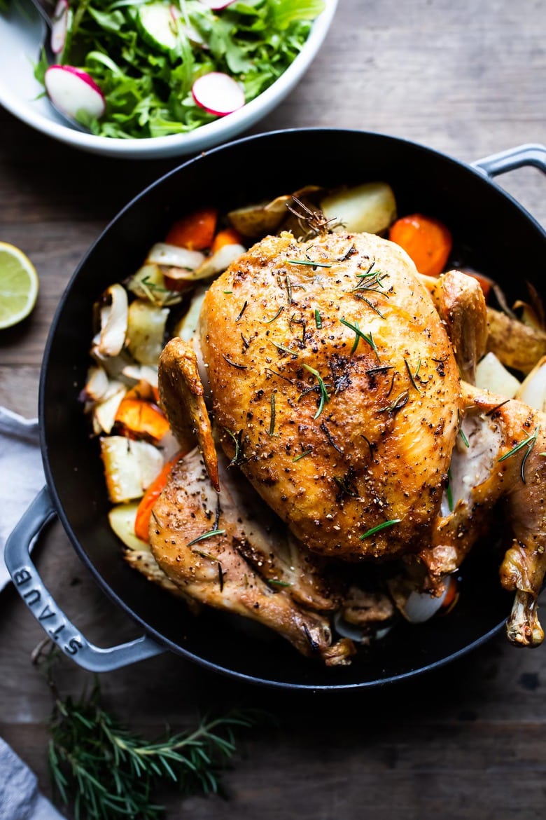 A simple easy recipe for roast chicken with lemon, garlic and rosemary, baked in the oven over vegetables. A delicious dinner recipe! #roastchicken