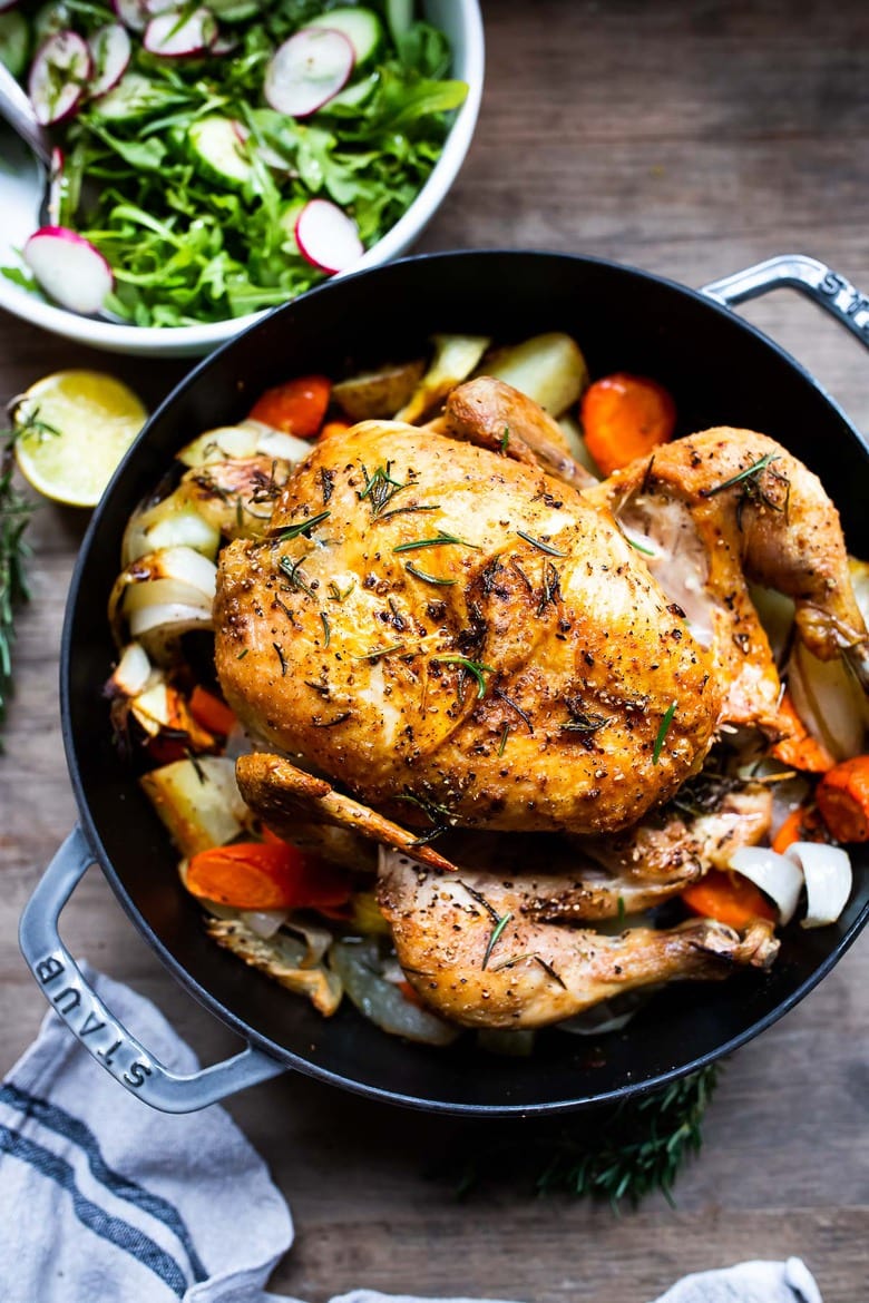 A simple easy recipe for roast chicken with lemon, garlic and rosemary, baked in the oven over vegetables. A delicious dinner recipe! #roastchicken