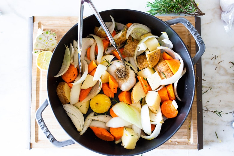 A simple easy recipe for roast chicken with lemon, garlic and rosemary, baked in the oven over vegetables. A delicious dinner recipe that can be turned into other meals during the week!