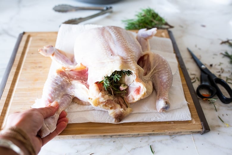 A simple easy recipe for roast chicken with lemon, garlic and rosemary, baked in the oven over vegetables. A delicious dinner recipe that can be turned into other meals during the week!