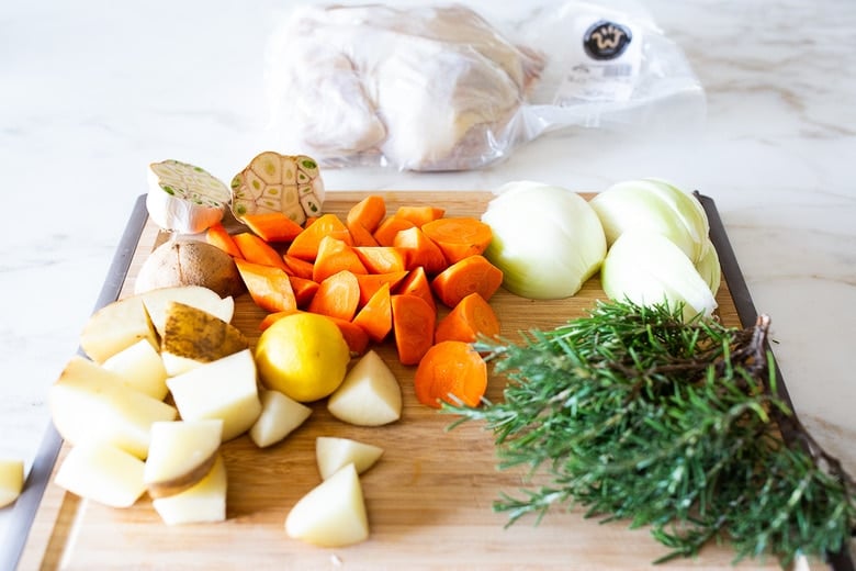 A simple easy recipe for roast chicken with lemon, garlic and rosemary, baked in the oven over vegetables. A delicious dinner recipe that can be turned into other meals during the week!