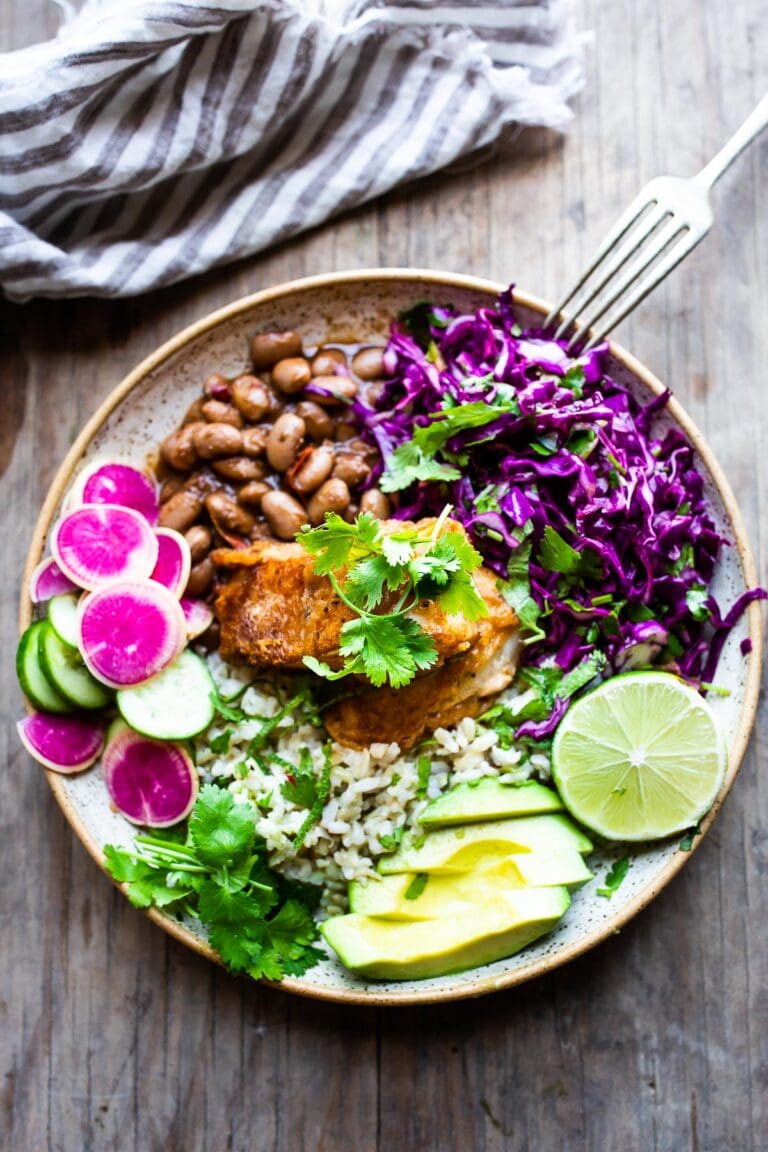Baha Fish Taco Bowls made with beer-battered cod, cilantro rice, pinto beans, Mexican Slaw, avacodo and Baja Sauce! #bajatacos #bajabowls #bajafishtaco #riceandbeans