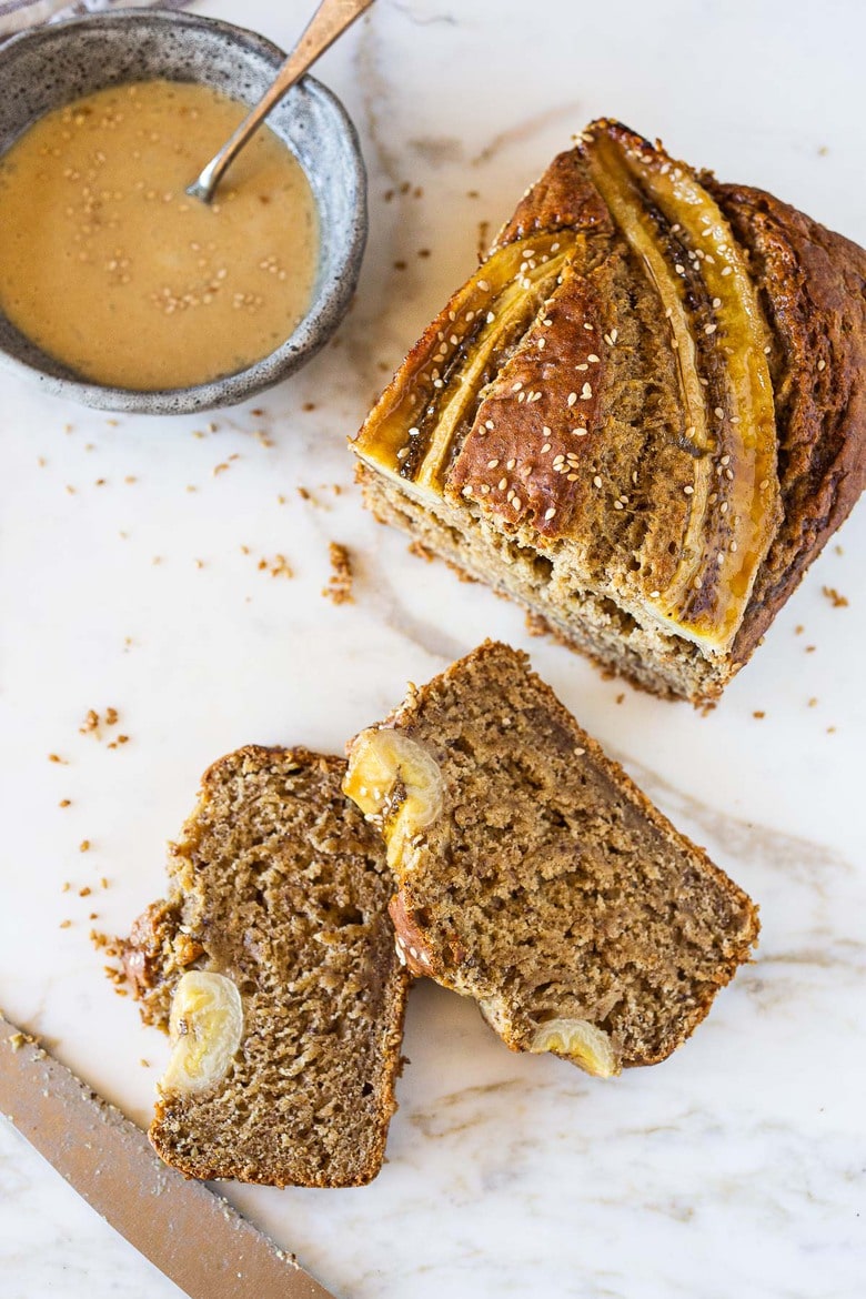 This Banana bread is not only healthy and vegan, but it can also be made with sourdough starter or discard! Infused with ginger, spices and crusted with sesame seeds it is flavorful and moist. #bananabread #veganbananabread #sourdough #yeastless