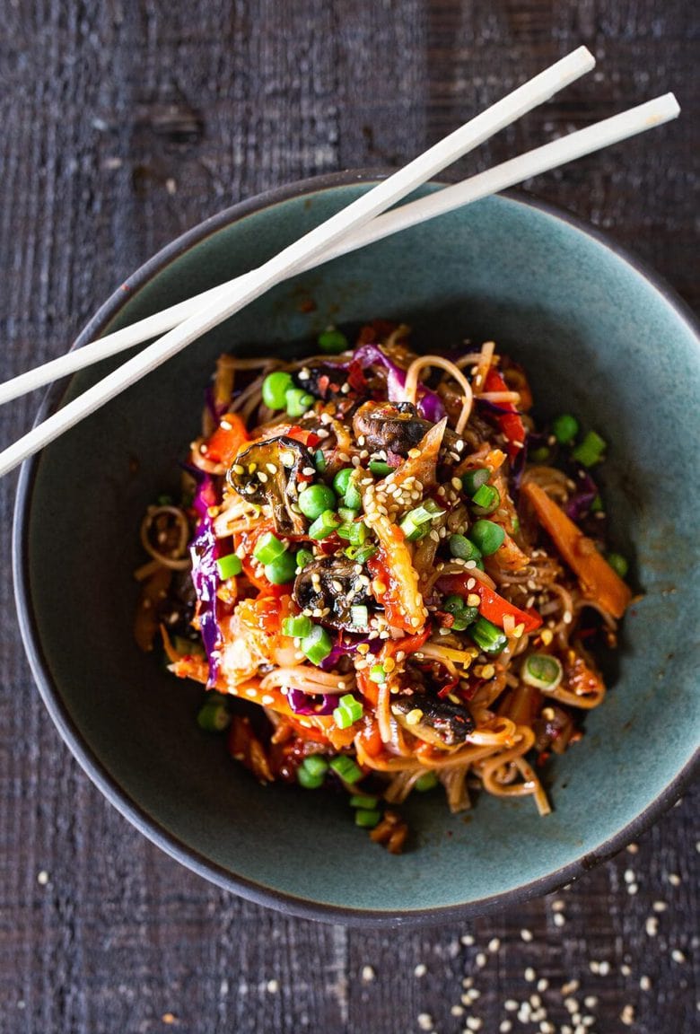 Here's a super tasty recipe for Vegan Kimchi Noodles, stir-fried with lots of healthy veggies you probably have on hand. Keep it vegan or add an egg, chicken or shrimp! Crispy tofu is also a delicious option here! #kimchi #kimchinoodles #kimchirecipes #vegannoodles