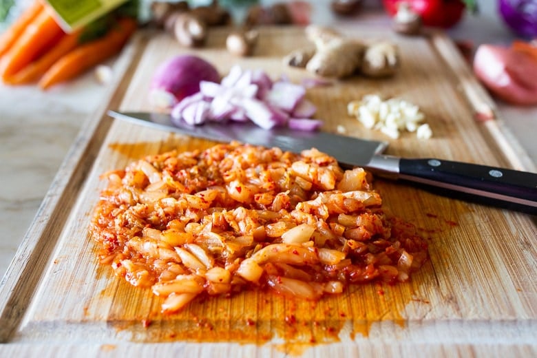 Here's a super tasty recipe for Vegan Kimchi Noodles, stir-fried with lots of healthy veggies you probably have on hand. Keep it vegan or add an egg, chicken or shrimp! Crispy tofu is also a delicious option here! #kimchi #kimchinoodles #kimchirecipes #vegannoodles